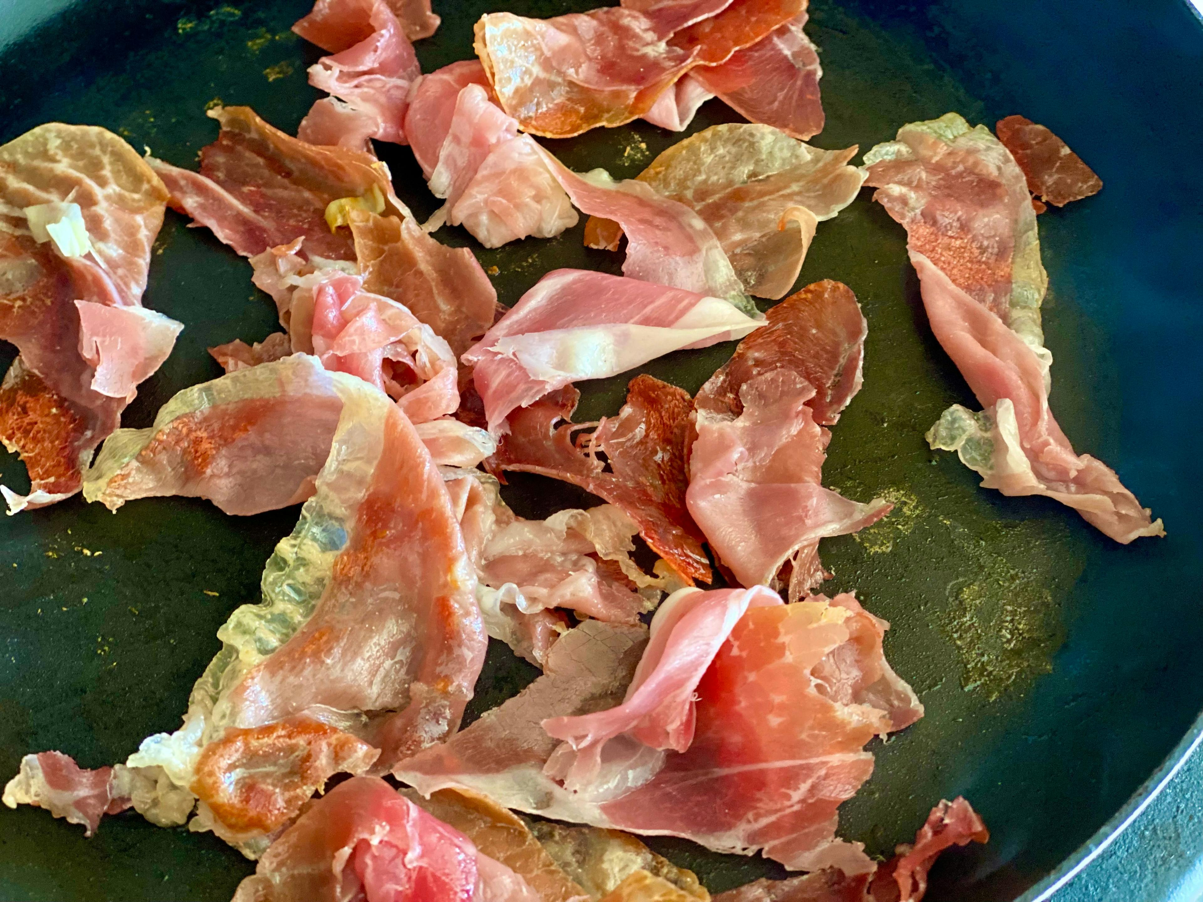 prosciutto frying in a pan