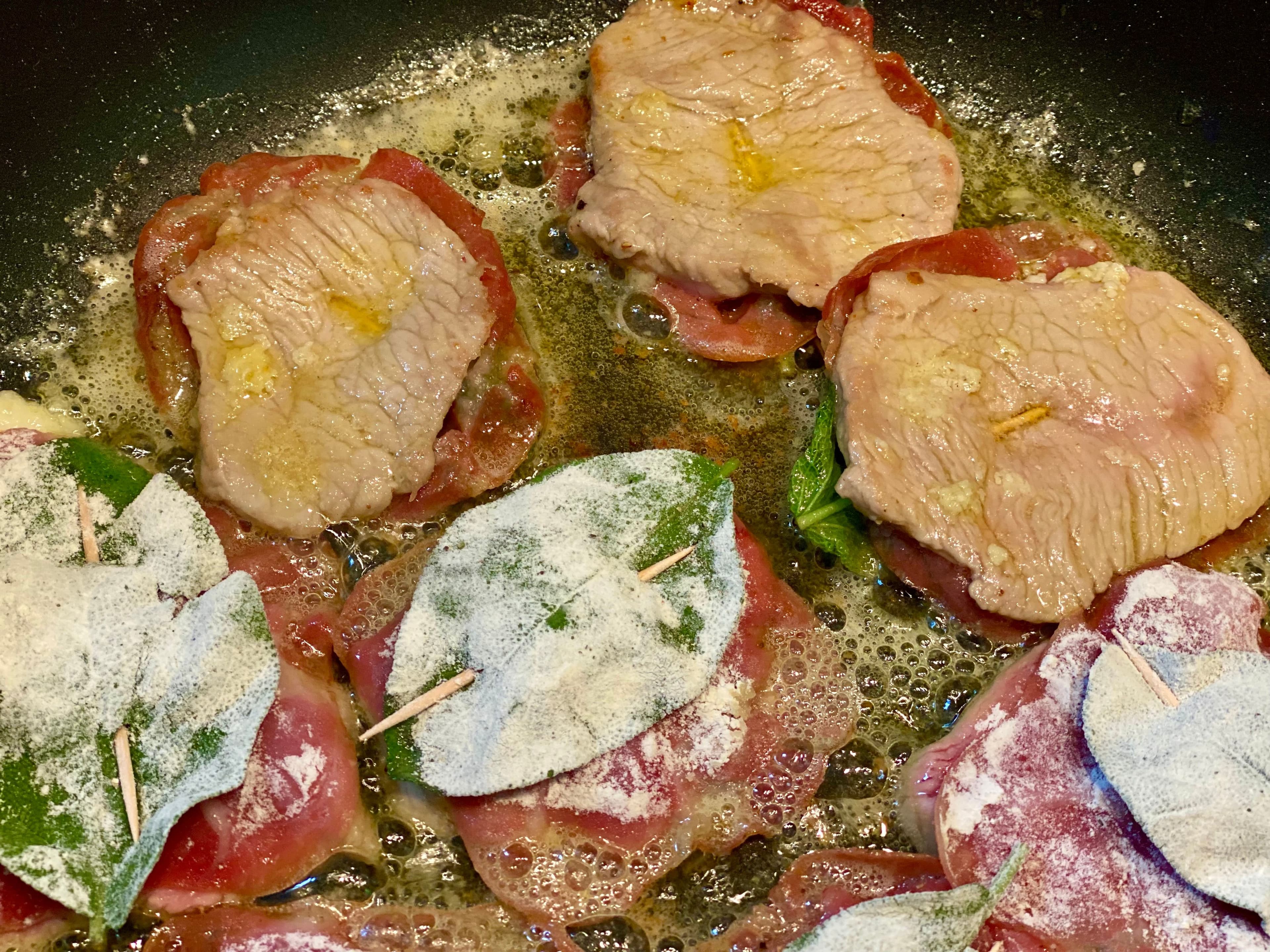 a frypan with the scaloppine frying in butter and oil